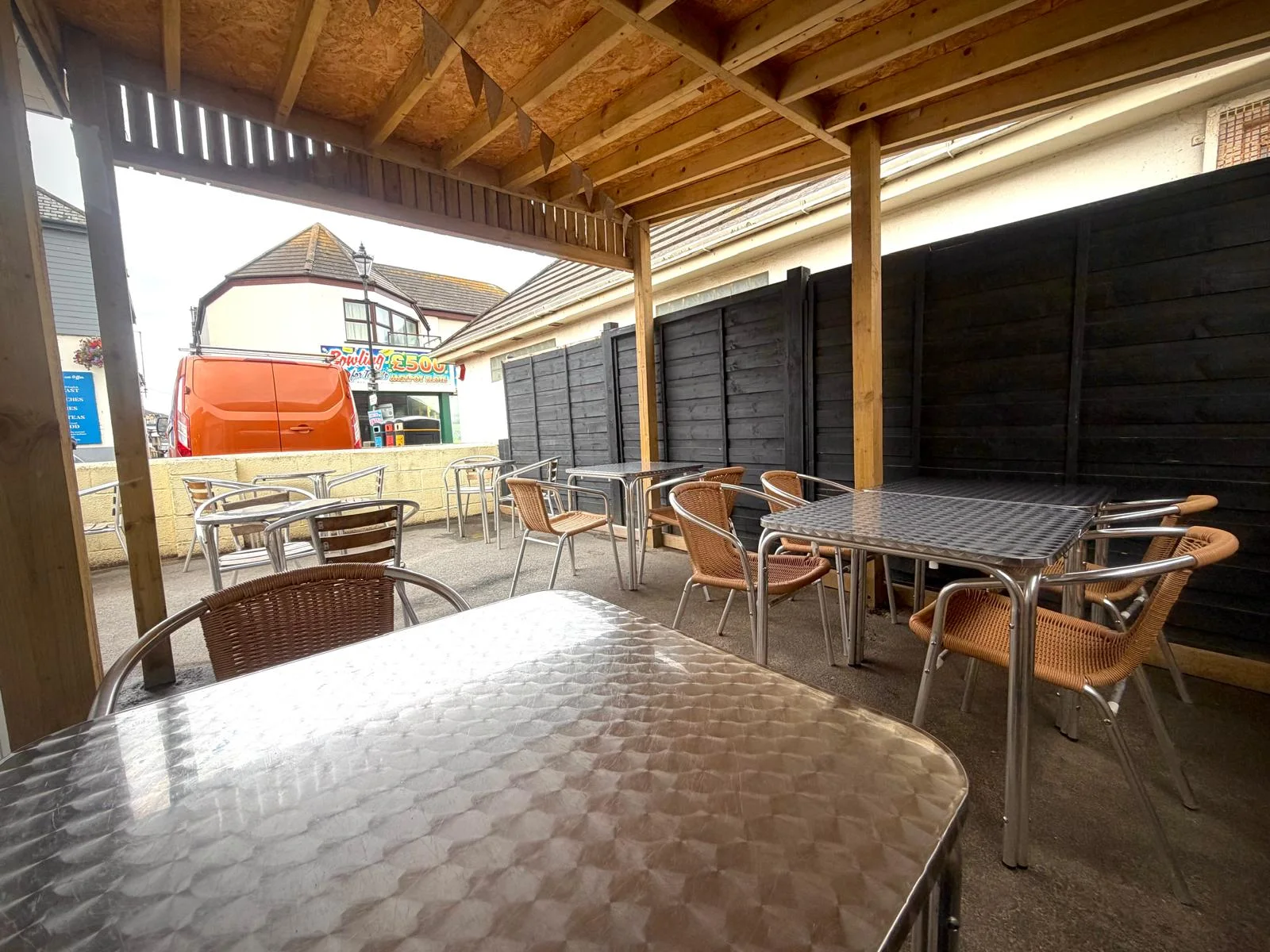 Covered outdoor seating area with tables and chairs at Cabana in Westward Ho!