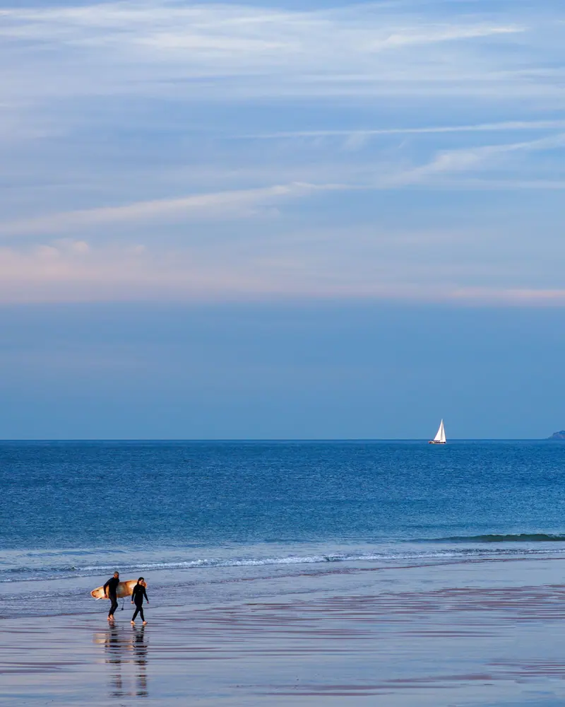 Surfers walking out into the sea at Croyde Bay