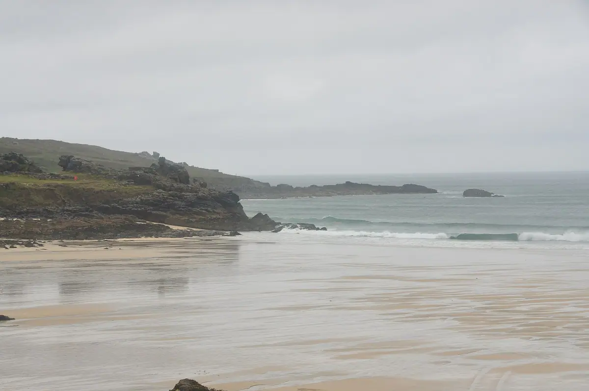 Porthmeor Beach, St Ives, at low tide with The Island headland beyond