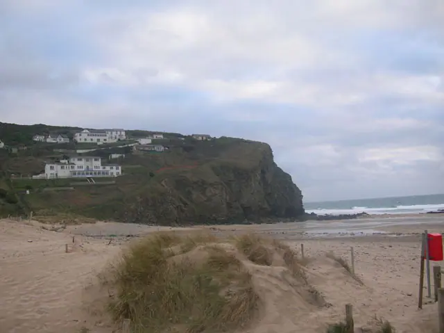 Porthtowan beach with dunes, the clifftop and buildings above